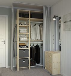 an organized closet with clothes and other items in grey tones, along with two gray bins