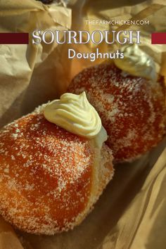 two pastries covered in powdered sugar sit on top of wax paper with the words sourdough doughnuts