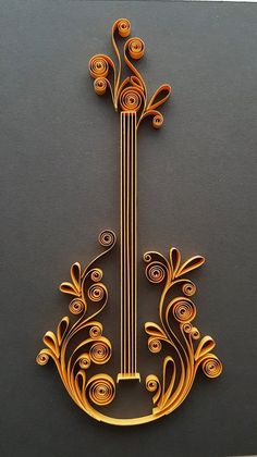 an intricately designed metal instrument on a black surface with gold swirls and leaves