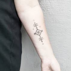 a person's arm with a tattoo on it and a cross in the middle