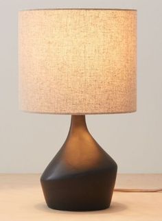 a lamp that is on top of a wooden table next to a white light bulb