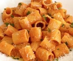 a white bowl filled with pasta and parmesan cheese