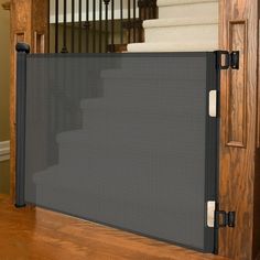 a black screen is on the floor in front of some stairs and stair railings