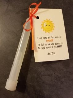 a note attached to a pen with an orange ribbon on it that says, i have come into the world as so that one man who belongs in me mean in the dark