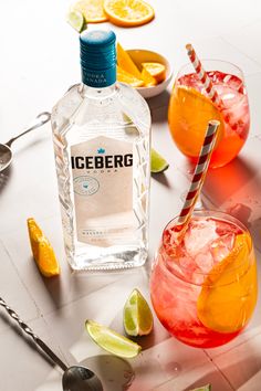 A bottle of Iceberg vodka sits on a tile counter next to two stemless wineglasses holding Cosmo spritz cocktails. Summer Vodka Drinks, Cranberry Vodka, Orange Wheels, Summer Drink Recipes, Vodka Drinks, Summer Drink