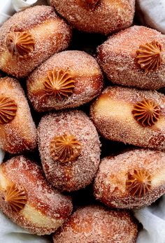 powdered sugar covered doughnuts in a white basket with orange decorations on them