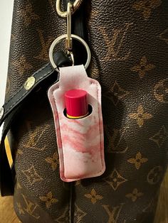 a handbag with a lighter in it and a keychain hanging from the handle