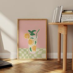 an orange drink in a tall glass with mint on the rim is framed next to a stack of books