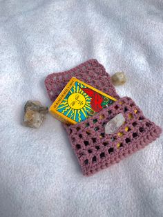 a crocheted book and rock on a blanket