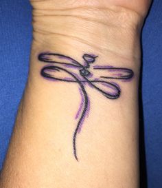 a wrist tattoo with a dragonfly on it