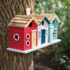 a bird house hanging from the side of a tree