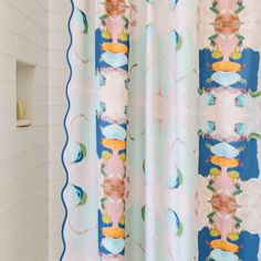 a shower curtain with an abstract design in blue, pink and yellow colors on it