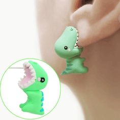 a pair of green dinosaur shaped earrings with spikes on the back of it's ear