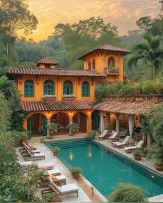 an outdoor swimming pool in front of a large yellow house with lots of greenery