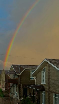 a rainbow in the sky over some houses