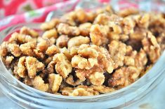 a glass bowl filled with walnuts on top of a table