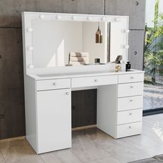 a white vanity with lights on it in front of a window