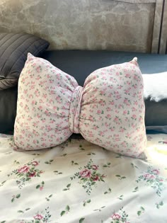 a bow tie pillow sitting on top of a bed