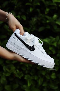 a person holding a white nike air force shoe