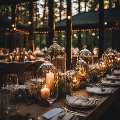 the table is set with candles, plates and napkins for an elegant dinner party