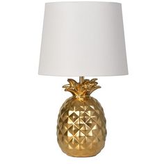 a gold pineapple lamp with a white shade