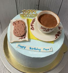 a birthday cake with a cookie and cup of coffee