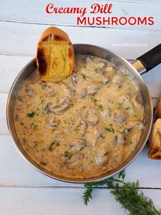 a pan filled with mushrooms and bread on top of a table