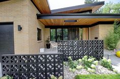 a house with a black fence and yellow balls in the front yard