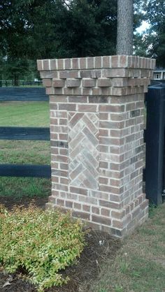 a brick fire hydrant in front of a fence