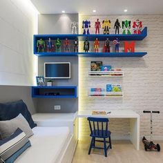 a bedroom with blue shelves and toy figures on the wall above it, next to a bed