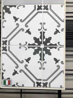 a white and black tiled wall next to a metal rack with an italian flag sticker on it