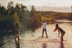 three girls playing in the water at sunset