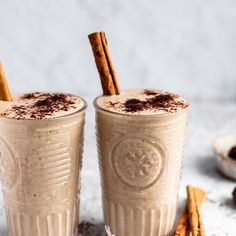 two glasses filled with coffee and topped with cinnamon sticks