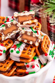 a white bowl filled with lots of pretzels and candy canes on top of each other