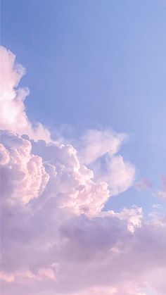 an airplane is flying high in the sky with clouds behind it and blue skies above