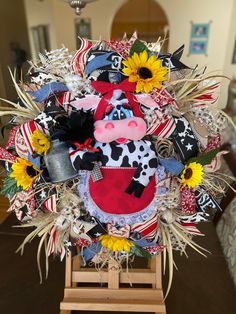 a cow wreath with sunflowers and other decorations