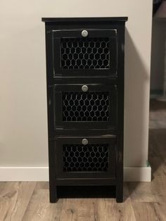 a small black cabinet with three drawers