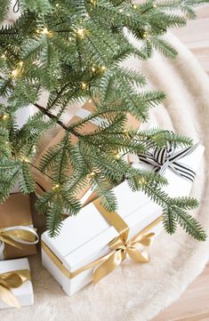 presents under the christmas tree are wrapped in gold and white paper