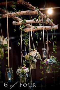 an arrangement of flowers hanging from a tree branch