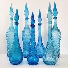 several blue glass vases lined up next to each other