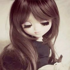 a doll with long brown hair and black eyeliners