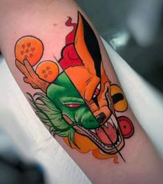 an orange and green tattoo on the arm