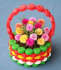 a basket with flowers in it sitting on a table next to a blue surface,