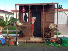 a small wooden structure with an image of a woman on the door and two men sitting in chairs behind it