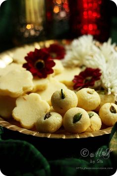 some food is on a gold plate with red and white flowers in the middle,