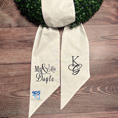 two wedding ties with the names mr and mrs doyle on them hanging from a wooden wall