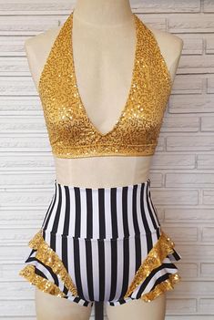 a mannequin with gold sequins and black and white striped swimsuit