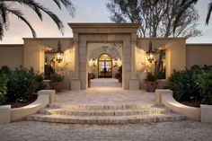 the entrance to a house with steps leading up to it and potted plants on either side