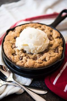 a chocolate chip cookie pie with ice cream on top sits on a red and white towel