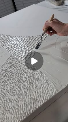 a person is using a paintbrush to paint a mattress